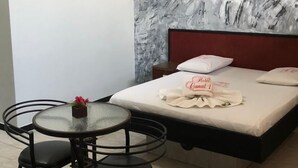 A hotel room with a bed, a small round table with two chairs, a decorative wall, and a bird decoration. - hotel Taguatinga sul (Taguatinga)