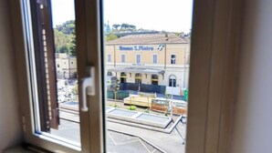 A view through a window of a building with a sign reading "Roma S. Pietro".