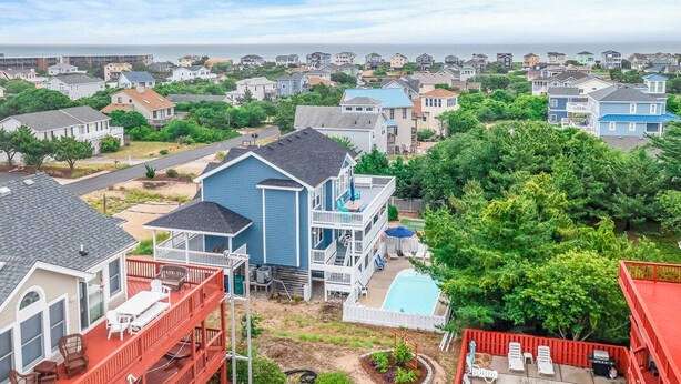 A residential area with houses, a swimming pool, and a view of the ocean. - Oceanside home in Duck NC with private mini golf course! (Duck)