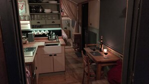 Una cocina compacta con pileta, alacenas y un comedor con mesa y sillas.