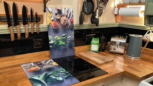 Una cocina con encimeras de madera, estufa integrada y diversos utensilios de cocina.