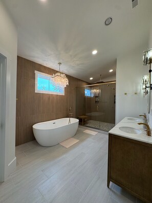 Un baño moderno con una bañera independiente, una ducha con cerramiento de vidrio y un lavabo con doble lavamanos.