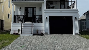 A two-story house with a garage, a staircase, and a balcony.