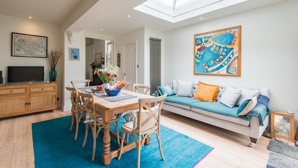 A spacious living area with a dining table, chairs, a sofa, and a large painting. - Warwick Villa, Walmer (Walmer)