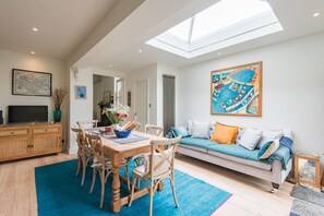 A spacious living area with a dining table, chairs, a sofa, and a large painting. - Warwick Villa, Walmer (Walmer)