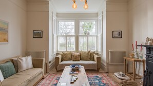 A cozy living room with a sofa, a coffee table, and a fireplace. - Warwick Villa, Walmer (Walmer)