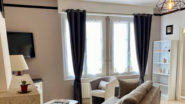 Una sala de estar moderna con un sofá, una mesa de centro, un televisor y una estantería.