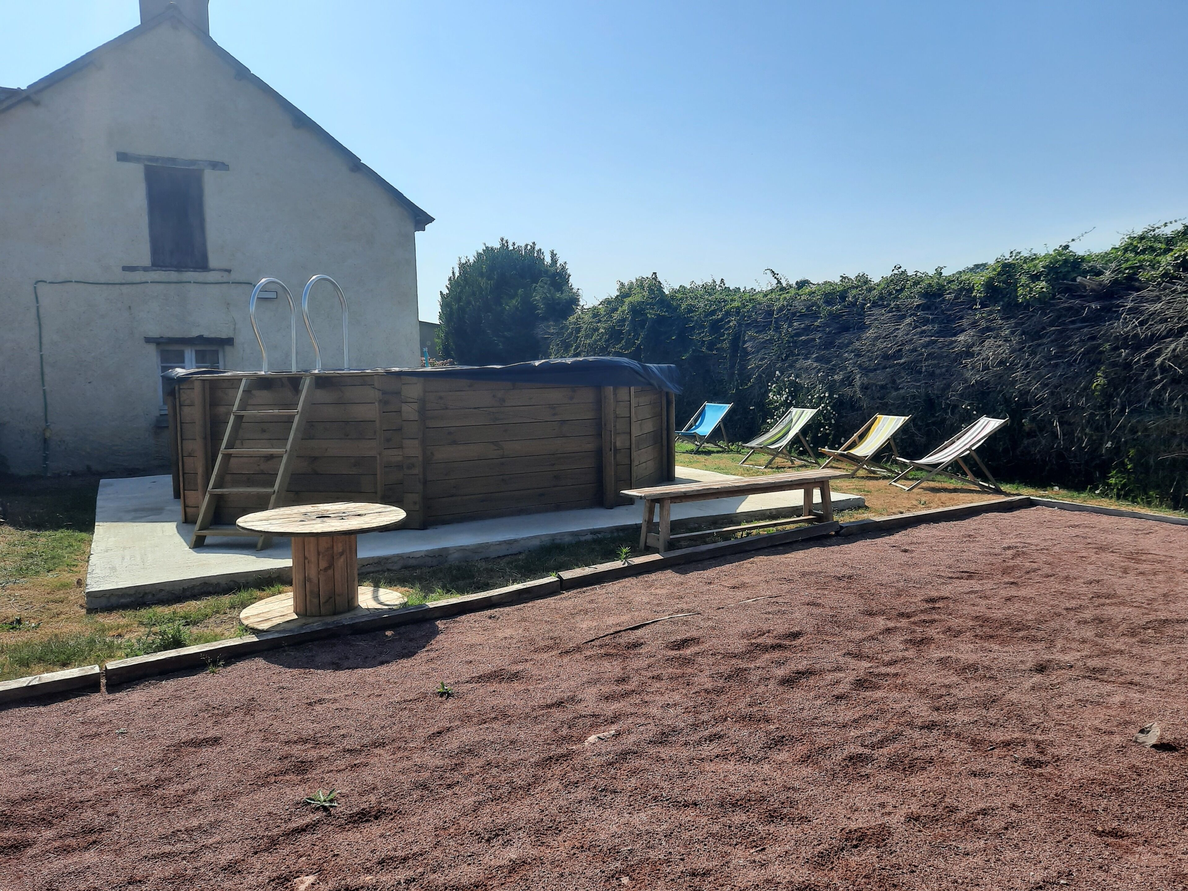 Un jardin avec une terrasse en bois, un barbecue et une table de billard.