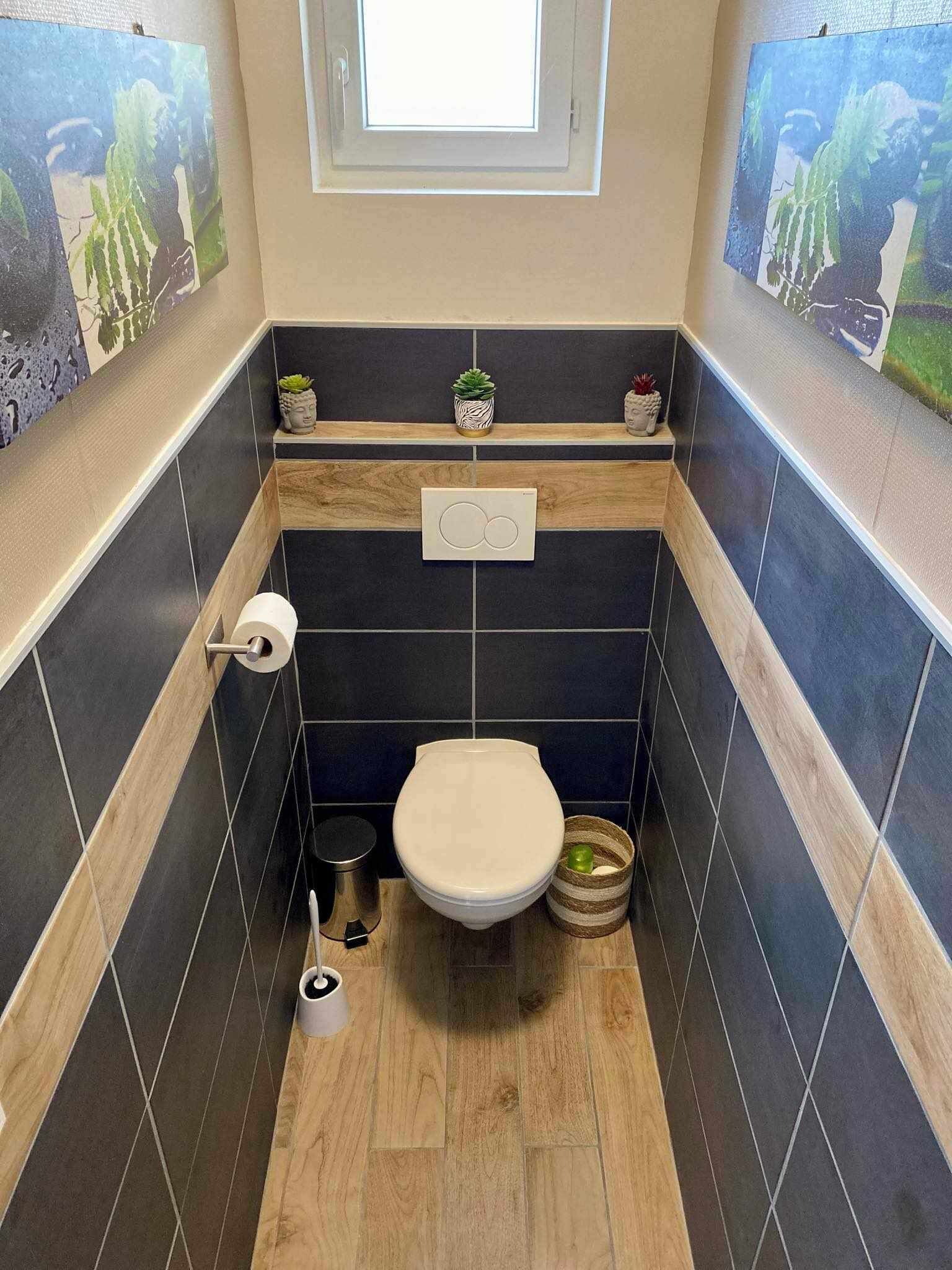 A small bathroom with a toilet, a hand dryer, a trash bin, and a window.