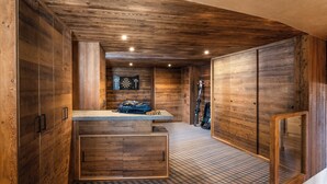 A wooden interior with a checkered floor, a counter with a bag, and skis leaning against the wall.