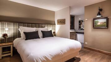 Une chambre à coucher avec un grand lit, des tables de chevet, une commode, un bureau et une chaise.