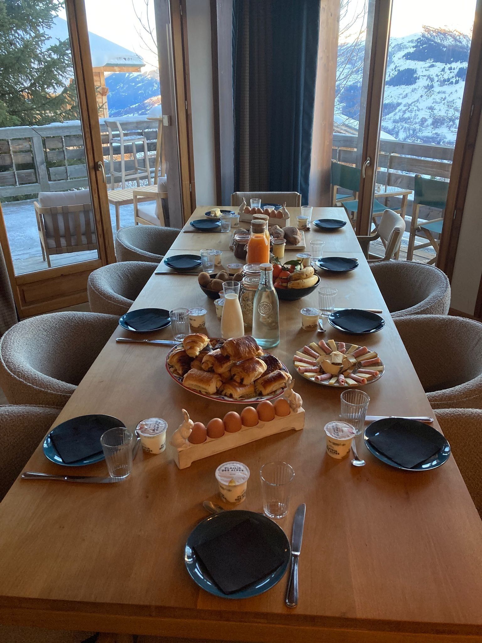 Una mesa de comedor dispuesta para una comida, con varios platos, vasos y cubiertos.