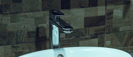 A white sink with a modern faucet on a countertop.