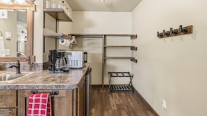 Una cocina con encimera de granito, cafetera y toallero colgante.