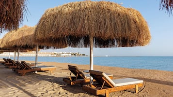 Playa privada, playa de arena blanca, camastros y sombrillas
