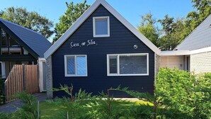 Une maison bleu foncé appelée « Casa de Silia », avec deux fenêtres et un jardin clos.