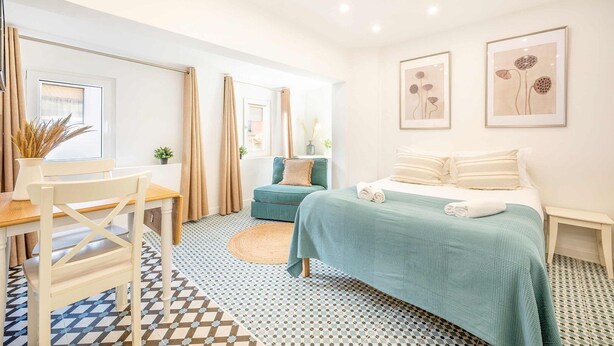 Une chambre moderne avec un lit, un bureau et une chaise. Deux tableaux encadrés sont accrochés au mur.