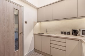 Een moderne keuken met een ingebouwd spoelgedeelte, kasten en een magnetron.
