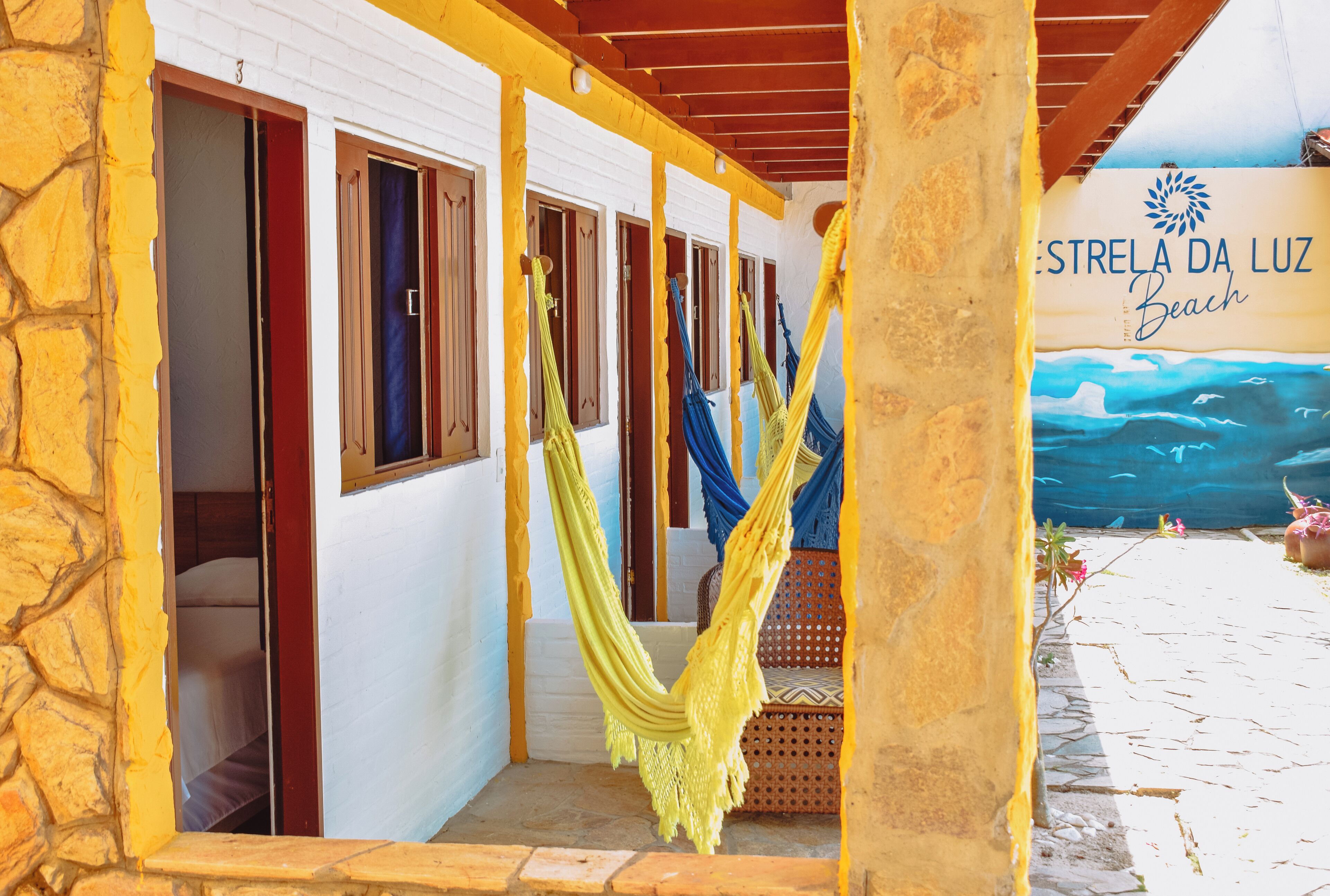 Une chambre avec un hamac, un lit et vue sur la plage.