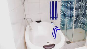 A modern bathroom with a freestanding bathtub, a glass-enclosed shower, and a white tiled floor.