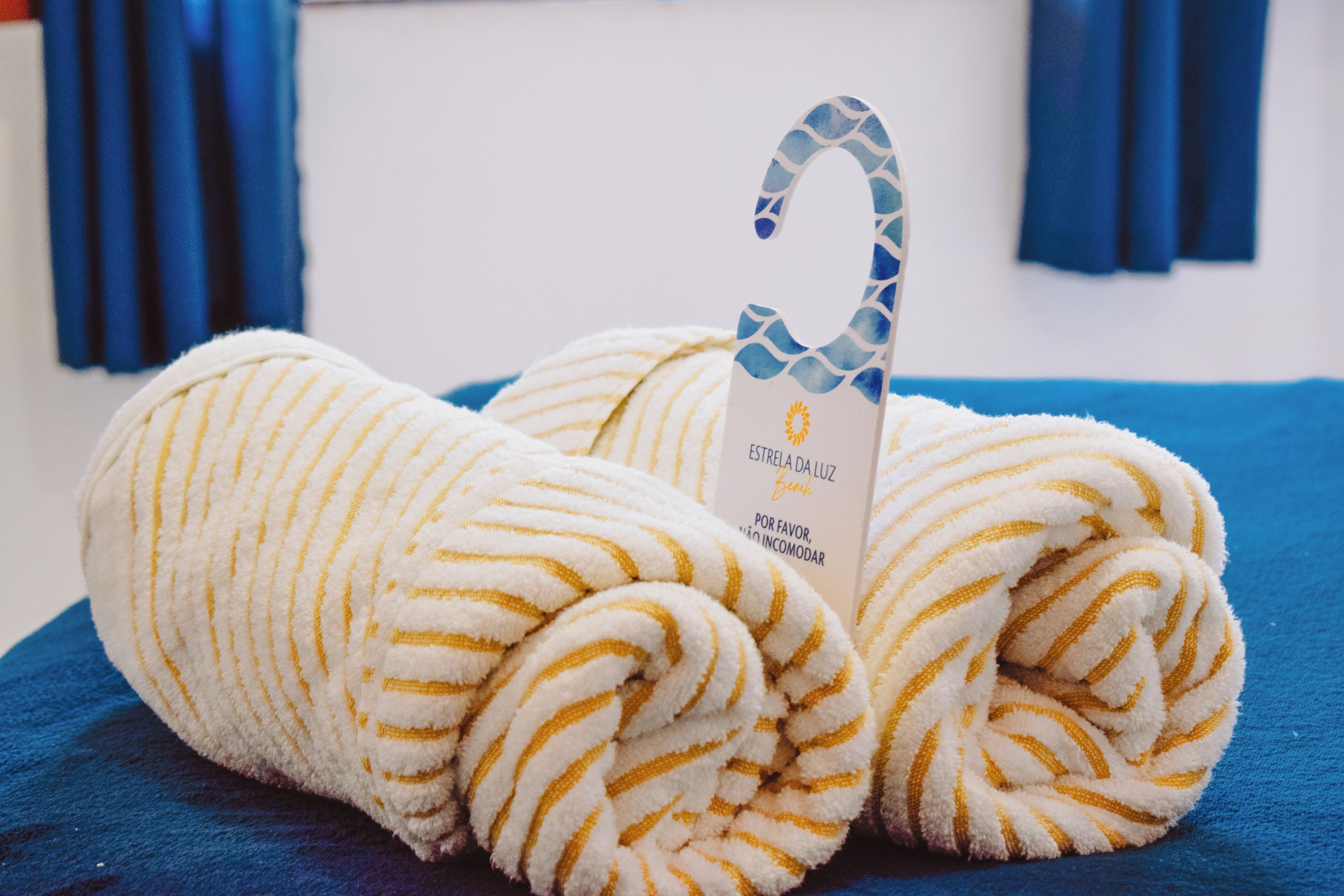 A rolled towel with a tag on a blue surface.