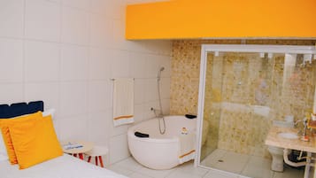 Et moderne badeværelse med badekar, bruser og toilet.