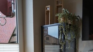 A room with a glass display cabinet containing wine glasses, a lamp, and a plant. - Fewo Schill und Mee(h)r, modern apartment in the center, pets allowed. (Wangerland)