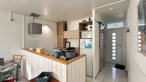 Une cuisine de taille réduite, dotée d’un plan de travail en bois, d’un four à micro-ondes et d’un réfrigérateur.