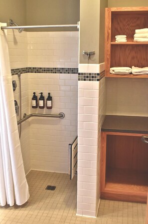 A bathroom with a shower, a handrail, a towel rack, and a tiled floor. - Johnson's Shut-ins State Park (Middle Brook)