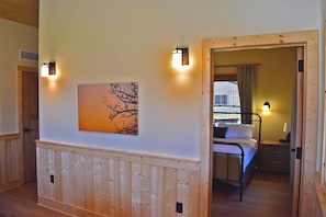 A bedroom with a bed, bedside table, and wall-mounted light fixtures.