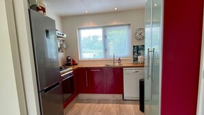 A compact kitchen with a refrigerator, stove, and sink.