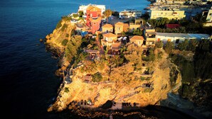Eine Luftaufnahme einer Küstenstadt mit Häusern, die an einer Klippe über dem Meer gebaut sind.