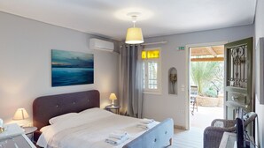 Ein Hotelzimmer mit Bett, Nachttischlampen, einem Gemälde, einer Klimaanlage und Blick nach draußen.