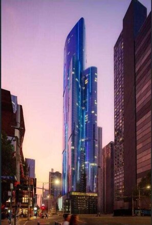 Un moderno edificio de gran altura con un diseño curvo único, rodeado de otros edificios altos.