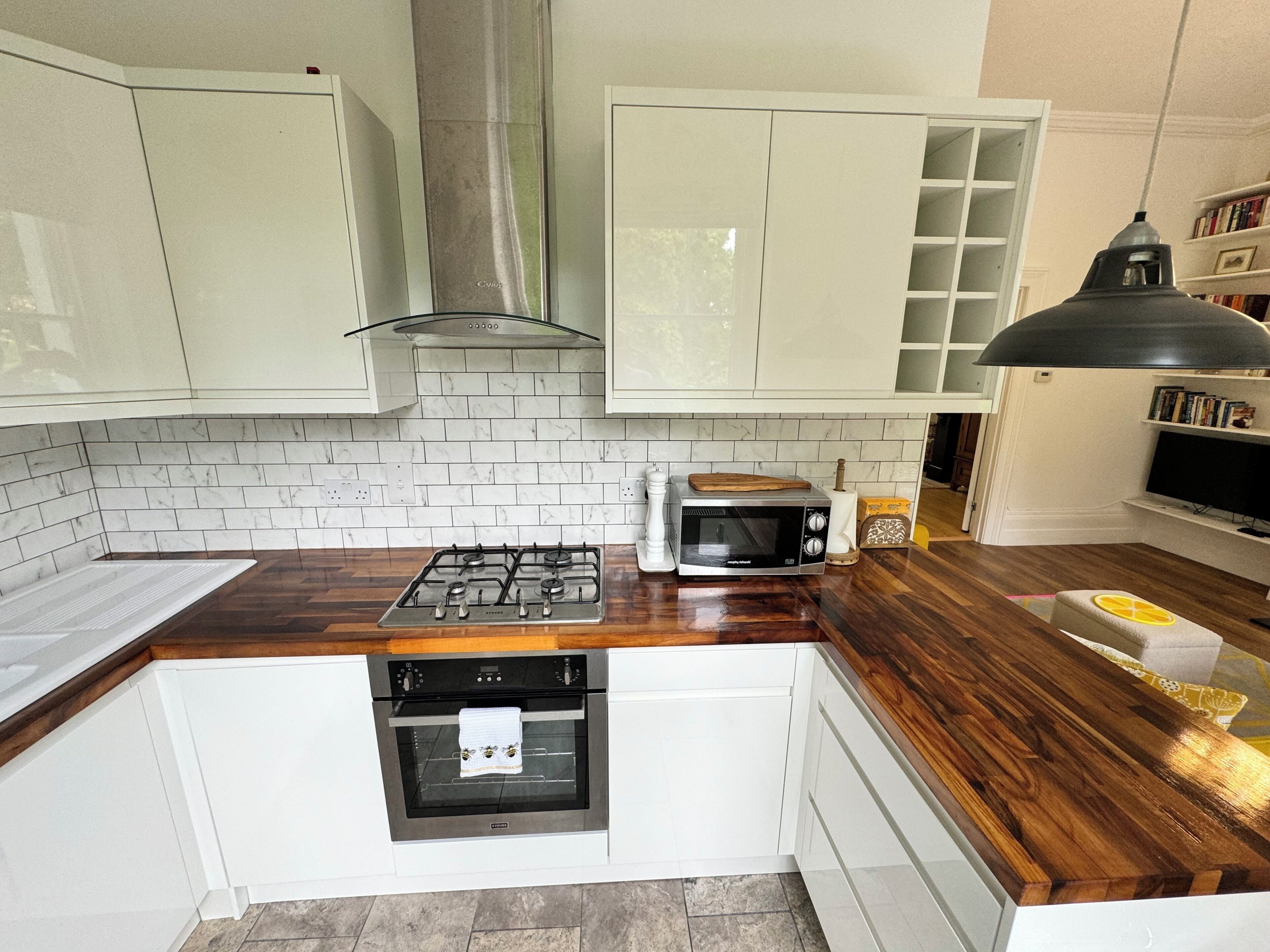 A kitchen with white cabinets, a gas stove, a microwave, and a built-in oven.