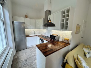 A compact kitchen with a built-in stove, a microwave, and a sink.