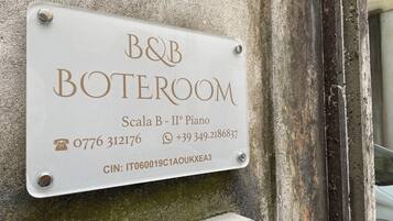 Señal para B&B Boteroom que indica la habitación número Scala B – II° Piso, con números de contacto y un código CIN.