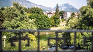 Vista de un pueblo con edificios y vegetación, incluyendo árboles y una masa de agua.