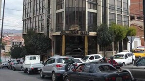 Un hotel con una facciata moderna, diverse finestre e un cartello con la scritta "GLORIA HOTEL".