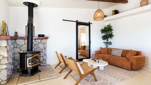 Un salon chaleureux avec une cheminée en pierre, un canapé et une table basse.