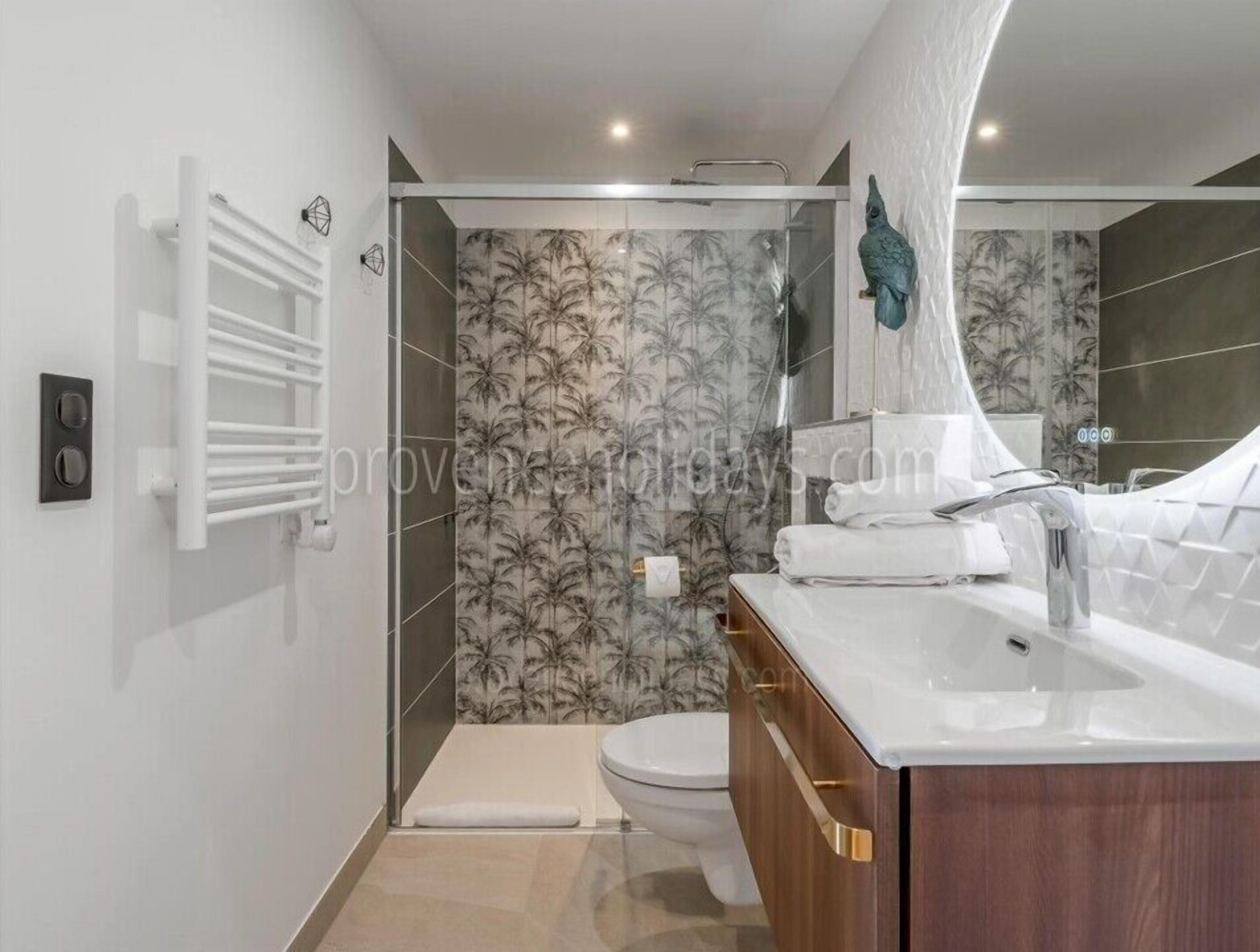 A modern bathroom with a shower, toilet, and vanity.