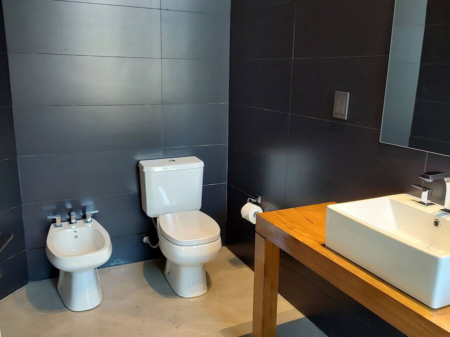 A modern bathroom with a bidet, toilet, and sink.