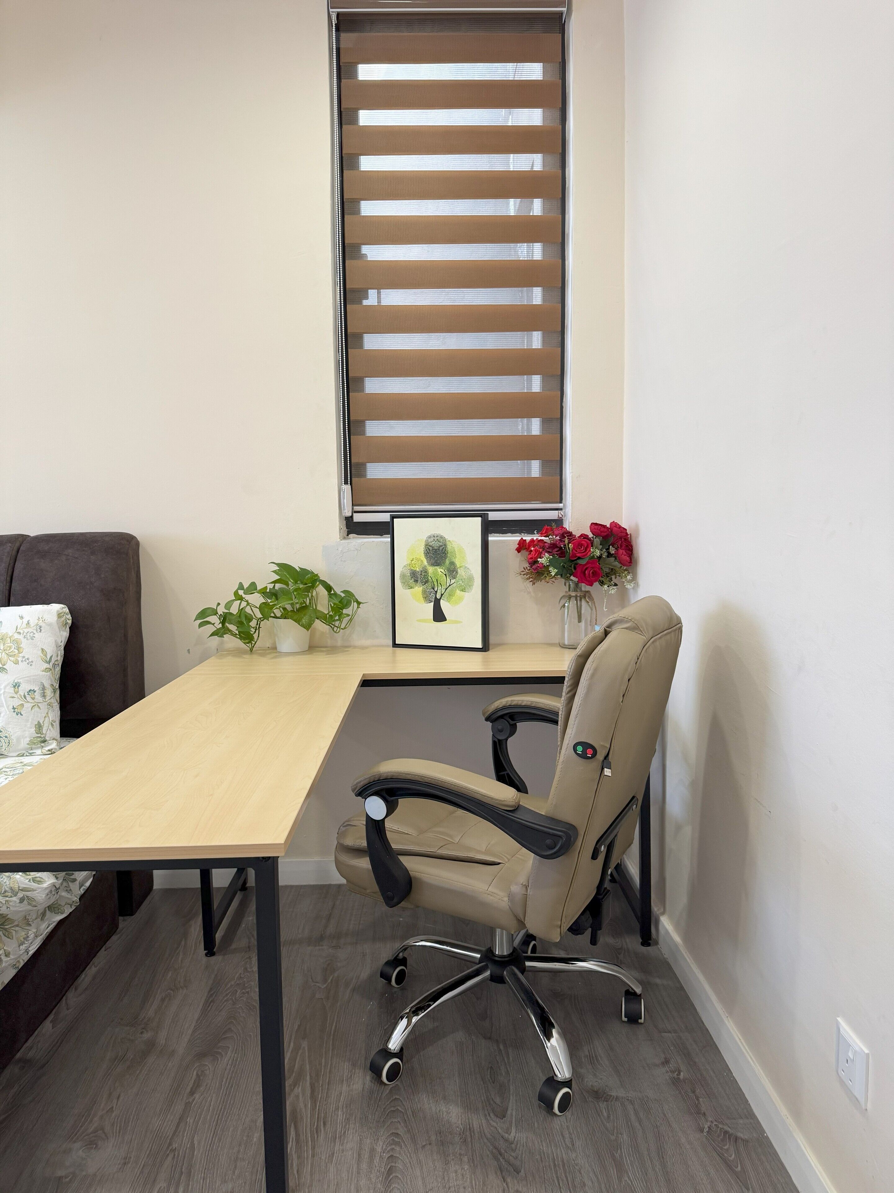 Un pequeño espacio de oficina con un escritorio, una silla y una ventana con persianas.
