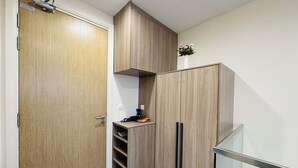 Una cocina moderna con armarios de madera, repisas empotradas y una pequeña encimera.