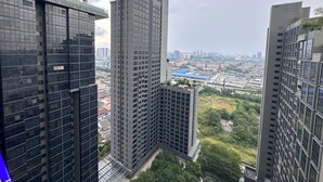 Un edificio alto con varios pisos, grandes ventanales y vistas a un paisaje urbano al fondo.