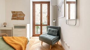 A bedroom with a bed, a desk, a chair, a window, and a door. - Casa Dolce Vita by Wonderful Italy (Palermo)