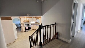 Une cuisine moderne avec des meubles en bois, un four encastré et un coin repas comprenant une table et des chaises.