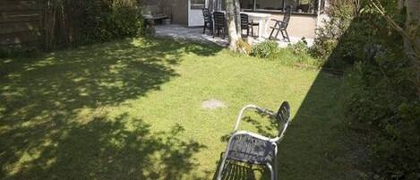 Une maison moderne dotée d’un patio, d’une table en bois et d’une chaise en métal.