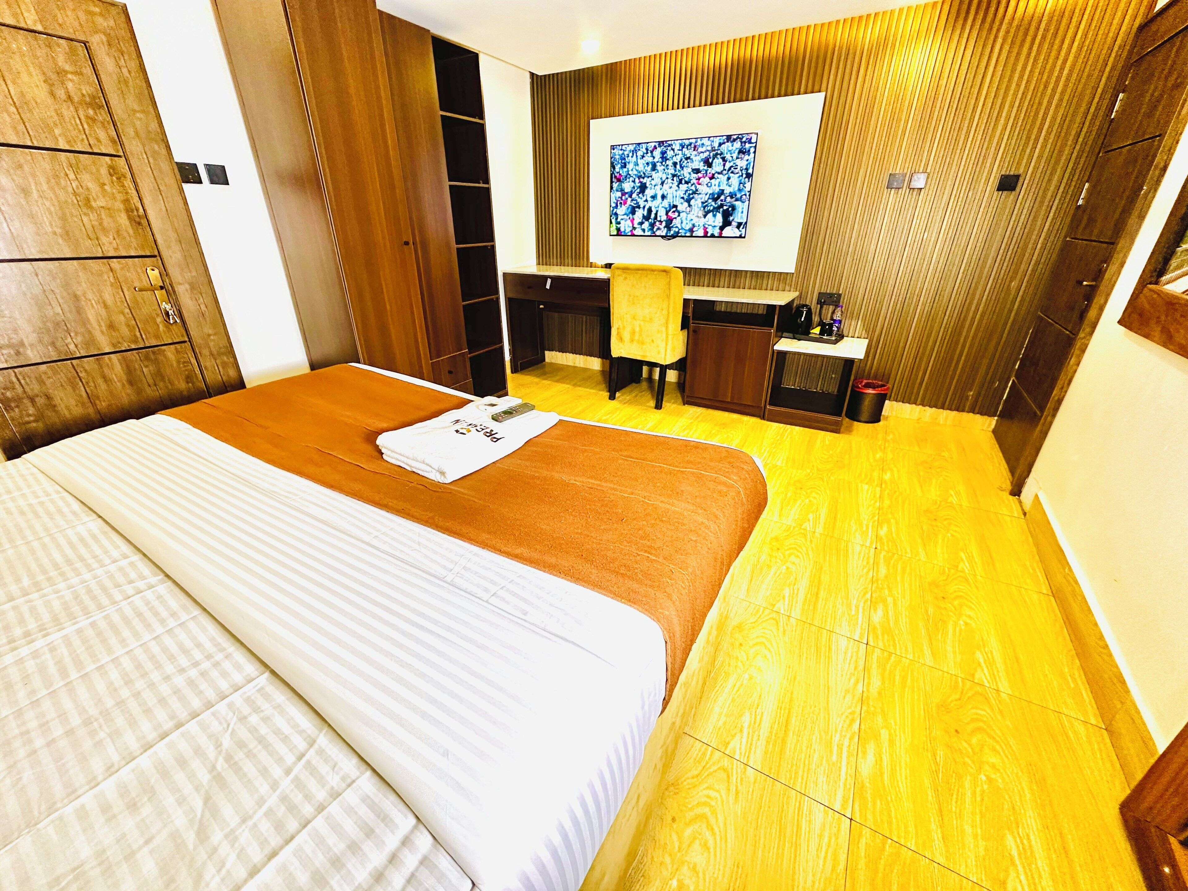 Ein Hotelzimmer mit einem Bett, einem Schreibtisch, einem Fernseher und einem Badezimmer.