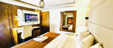 A hotel room with a bed, a desk, a television, and a mirror.